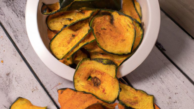 Imagem de uma cesta de fritadeira cheia de chips de abobrinha fritos e crocantes, guarnecidos com ervas frescas e sal marinho.