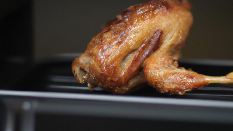 Imagem de costelinhas de porco crocantes e douradas cozidas em uma airfryer. As costelinhas são cortadas em pedaços pequenos e empanadas com uma mistura de especiarias e ervas. Elas são dispostas em uma cesta de airfryer e cozidas até ficarem crocantes e cozidas.