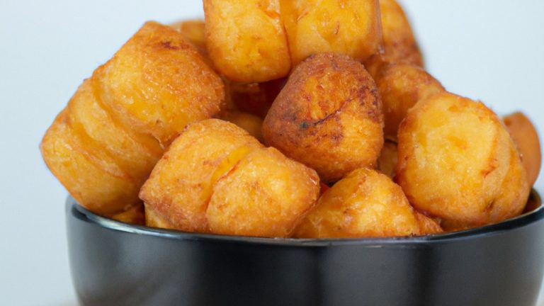 Imagem mostra duas coxas de frango e duas sobrecoxas de frango assadas na Airfryer. As peças de frango estão douradas e crocantes, com uma leve crosta temperada. O fundo da imagem tem um fundo preto liso.