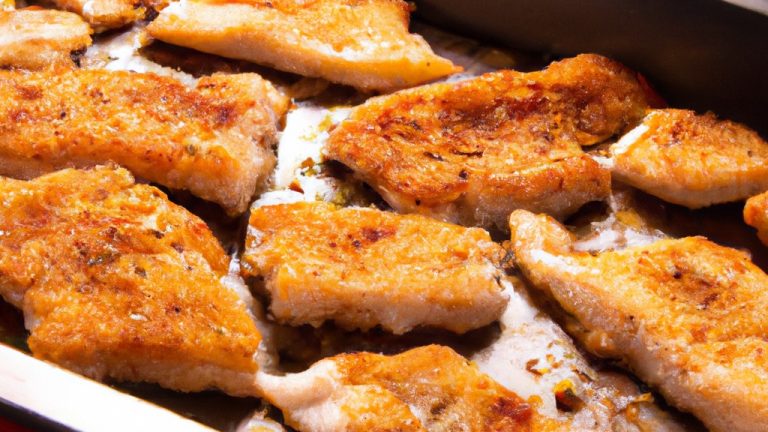 Imagem de filés de peixe empanados e dourados em uma fritadeira Airfryer. Os filés são empilhados em uma cesta de fritura com uma guarnição de limão fatiado e ervas frescas.