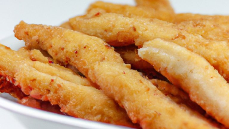 Imagem de filés de peixe empanados fritos na airfryer, crocantes e dourados, acompanhados de molho tártaro e limão.
