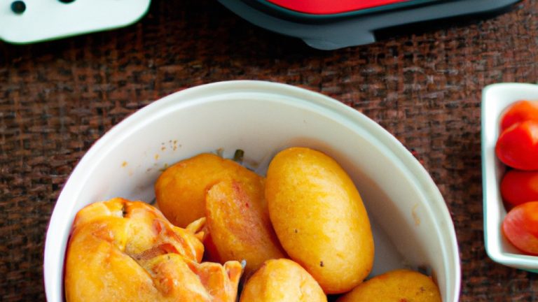 Uma foto de cima para baixo de um prato com frango e batatas cozidos na Airfryer. O frango é dourado e crocante, e as batatas são macias e fofas. O prato é guarnecido com salsa fresca.