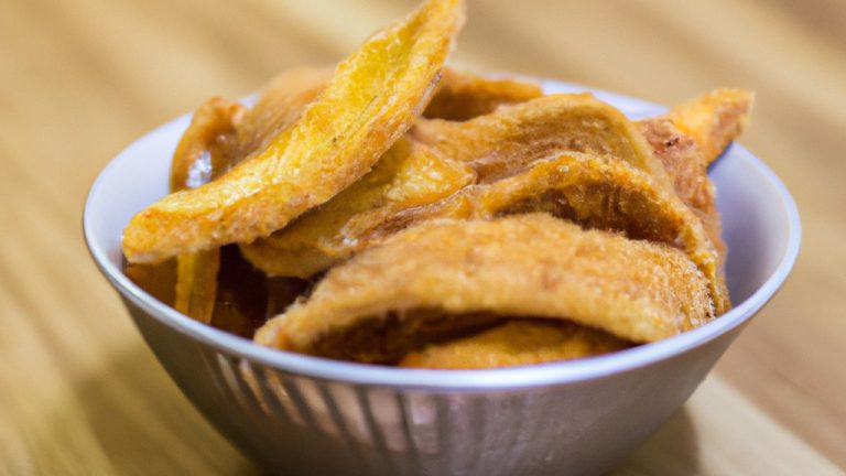 Imagem de palitos de pão crocantes e dourados feitos com massa de pizza caseira e cozidos na Airfryer. Os palitos são polvilhados com sal marinho e ervas secas e são apresentados em uma tigela de cerâmica branca.
