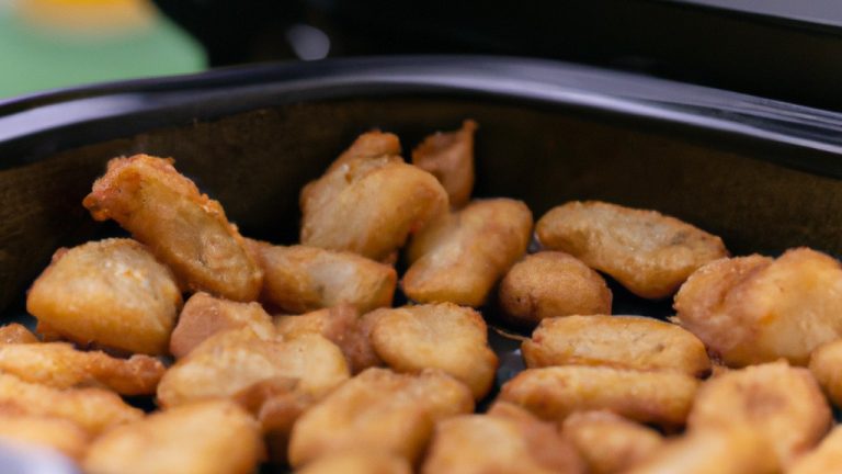 Imagem de linguiças toscanas frescas fritas em uma Airfryer. As linguiças estão dispostas em uma cesta de cozimento, com a pele externa dourada e crocante. O interior da linguiça é visível, mostrando a carne rosa e suculenta. A imagem também mostra uma tigela de molho de tomate à parte.