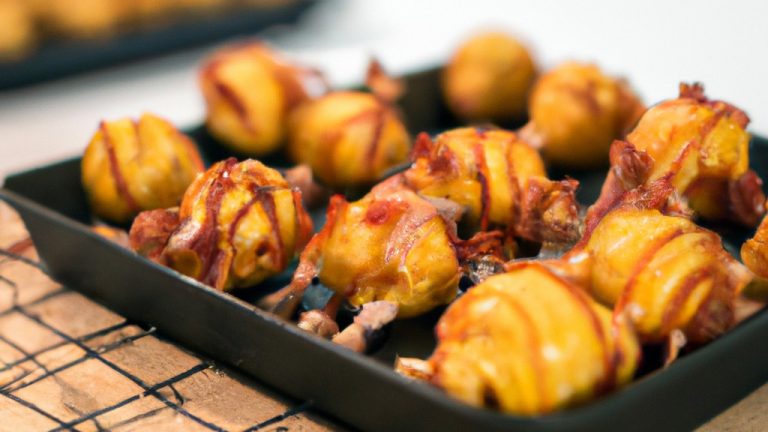 Uma foto aproximada de mini batatinhas douradas e crocantes em uma tigela, cobertas com cheddar derretido e pedaços de bacon crocante. As batatinhas são cozidas na Airfryer, resultando em uma textura perfeitamente crocante por fora e macia por dentro.