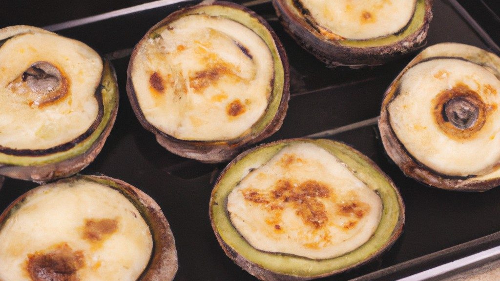 Imagem de pequenas pizzas redondas feitas com fatias de berinjela assadas na Airfryer. As pizzas são cobertas com molho de tomate, queijo e outros ingredientes como pimentões, cogumelos e azeitonas. As pizzas são servidas em uma tábua de madeira.