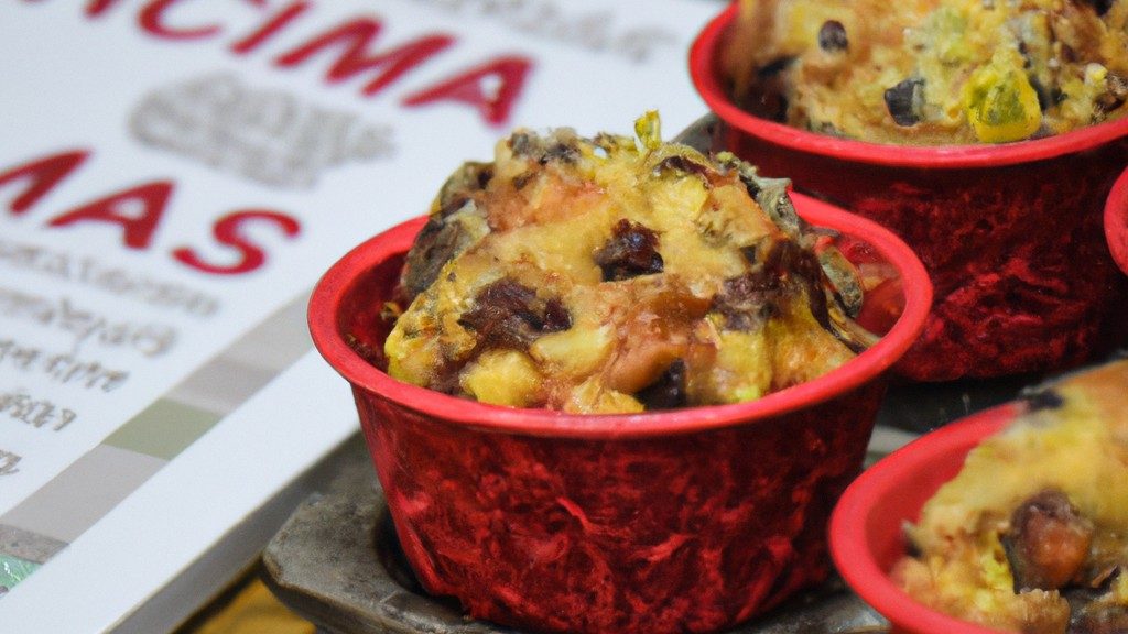 Imagem de muffins natalinos caseiros quentes e fumegantes feitos na Airfryer. Os muffins são decorados com glacê branco e vermelho e cobertos com granulado festivo. Eles estão dispostos em uma cesta forrada com papel manteiga, cercados por pinhas e azevinho.