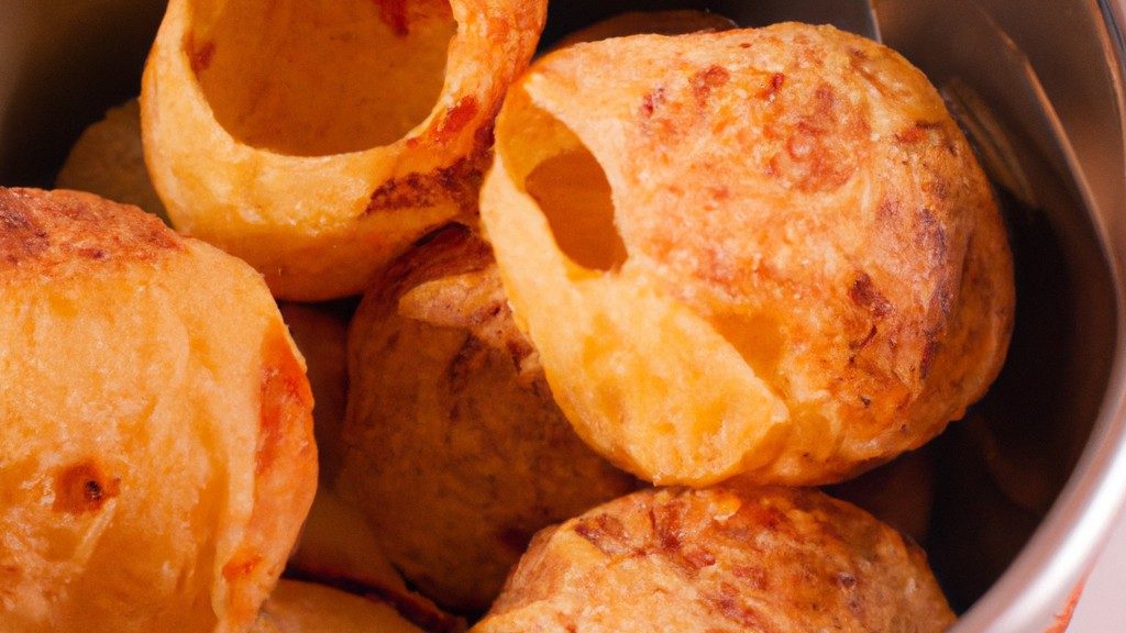Imagem de um pão de alho com queijo assado na Airfryer. O pão é coberto com uma crosta dourada e crocante e recheado com uma mistura cremosa de alho, ervas e queijo derretido.