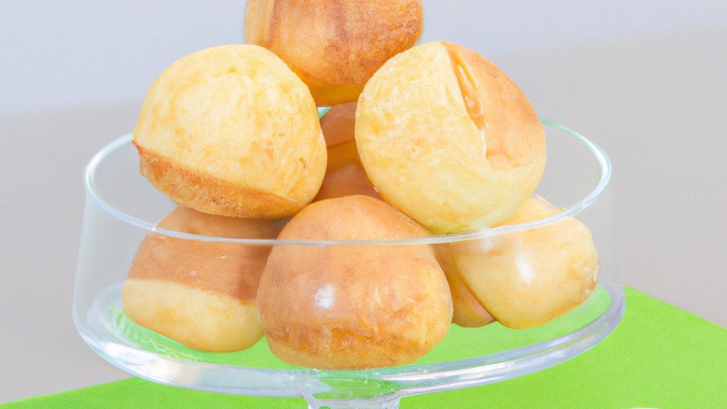 Imagem de pães de queijo dourados e crocantes, recém-saídos da airfryer. Os pães de queijo estão dispostos em um prato, prontos para serem apreciados.