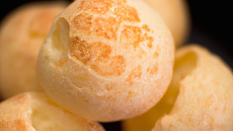 Imagem de pães de queijo dourados e crocantes cozidos em uma airfryer. Os pães de queijo têm um exterior crocante e um interior macio e arejado, e são servidos em um prato.