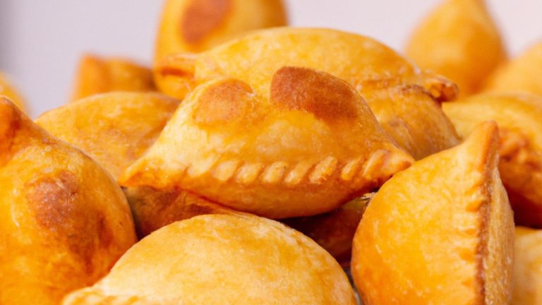 Imagem de um prato de pastel caseiro frito na airfryer. O pastel é feito com massa caseira e recheado com uma mistura de carne moída, cebola, tomate e temperos. O pastel é frito até dourar e ficar crocante.