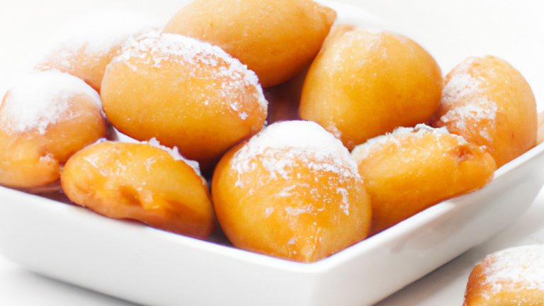 Imagem de um pastel frito em uma airfryer. O pastel é dourado e tem um recheio branco cremoso. Há uma tigela de molho vermelho ao lado do pastel.