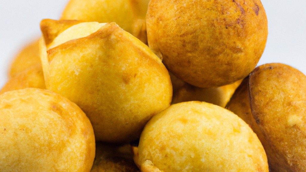 Imagem de uma assadeira com polpetones recheados cozidos na Air Fryer. Os polpetones são dourados e crocantes, com recheio de queijo derretido visível. Eles estão dispostos em uma camada única na assadeira, com espaço entre eles para permitir a circulação de ar.