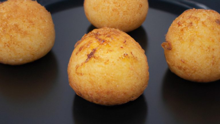 Imagem de um prato com Provoleta assada na Airfryer. O queijo está derretido e dourado, coberto com orégano e flocos de pimenta vermelha. A Provoleta é servida com fatias de pão crocante para mergulhar.