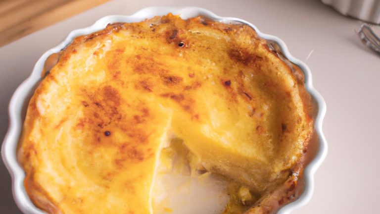 Imagem de uma quiche integral de alho-poró cozida em uma airfryer. A quiche está em uma forma de torta redonda e tem uma crosta dourada. O recheio é verde escuro e contém alho-poró, ovos e queijo.
