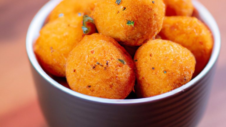 Uma imagem de uma airfryer em uma bancada de cozinha. A airfryer é branca e tem um cesto preto removível. Atrás da airfryer, há uma pilha de livros de receitas.