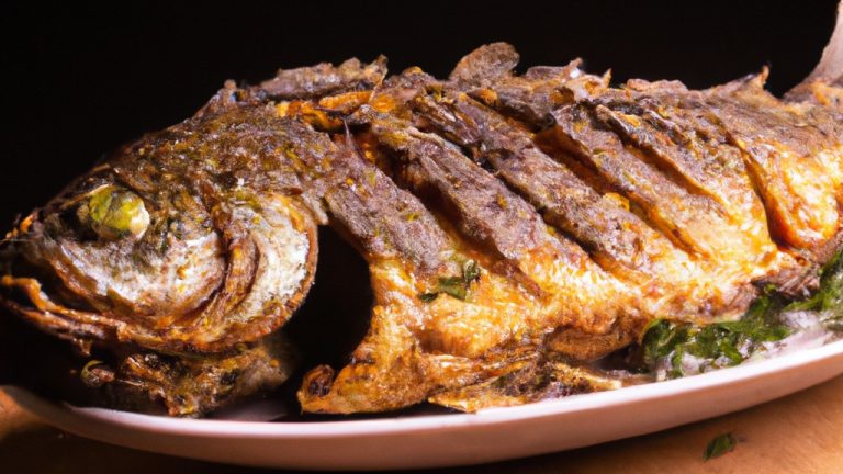 Imagem de um prato de peixe cozido na Airfryer, com limão e ervas.
