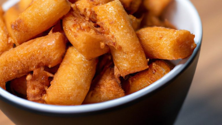 Imagem de palitos de muçarela crocantes e dourados preparados na Airfryer. Os palitos são feitos com queijo mussarela de alta qualidade, empanados com farinha de rosca temperada e fritos até ficarem crocantes e derretidos por dentro. A imagem mostra os palitos dispostos em uma cesta de fritadeira, prontos para servir como um aperitivo delicioso e satisfatório.
