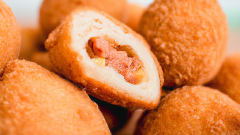 Imagem de coxinhas de asa douradas e crocantes cozidas em uma Airfryer, servidas em um prato com um molho de acompanhamento.