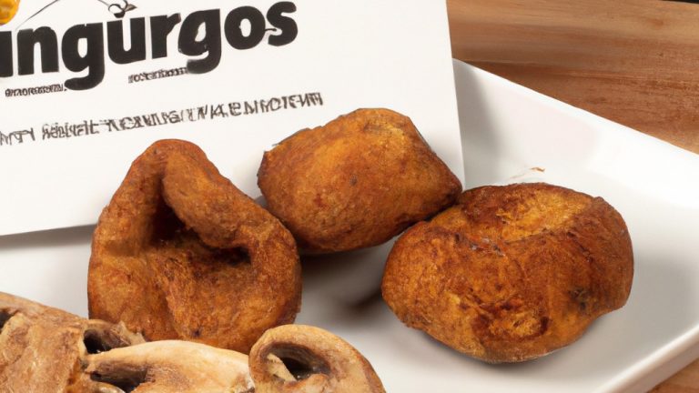 Imagem de uma cesta cinza cheia de cogumelos fritos na Airfryer. Os cogumelos são dourados e crocantes, com algumas ervas verdes espalhadas por cima.