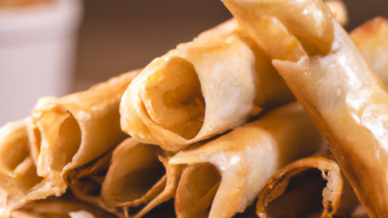 Imagem de uma crepioca feita na Airfryer, com recheio de queijo e presunto. A crepioca está cortada em quatro pedaços e disposta em um prato.